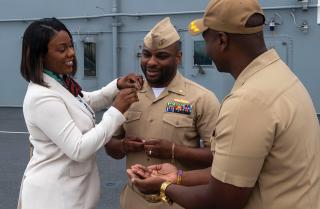 The due-course route leads to many happy moments, as promotions accrue and officers pin on new rank. Here, an officer receives his silver oak leaves from his wife in a ceremony on board the USS Boxer (LHD-4).