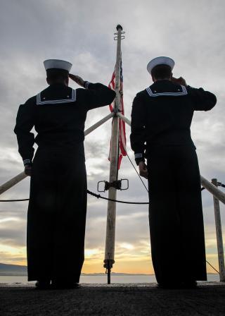 Sailors embarked on board the USS George H. W. Bush (CVN-77) salute the American flag. The polarized political climate in the United States can strain relationships, so Navy leaders must know how to ensure and encourage productive political discourse.