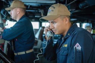 junior officer of the deck relays maneuvering information to his ship’s combat information center. Officers of the deck are often junior officers responsible for the safety their ship and all the sailors on board.