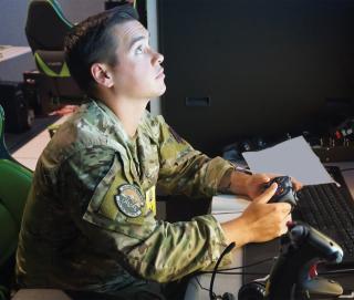 Air Force airman using a hand-held video game controller