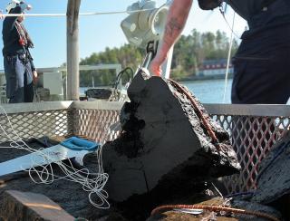 Marine archaeologists salvage a broken-off piece retrieved from the shipwreck