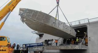 An unmanned surface vehicle is craned on board the USS Canberra (LCS-30) as part of the first embarkation of the littoral combat ship mine countermeasures mission package in April 2023.