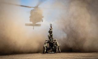 U.S. Army artillerymen prepare to sling load an M119 105-mm howitzer to a helicopter. Because it can be towed by Humvee-size vehicles and is easier to airlift than the M777, the M119 is a more expeditionary weapon system and better suited to movement in challenging littoral terrain.
