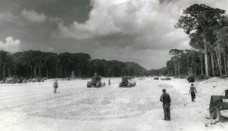 Seabees of the 87th NCB compact and grade Treasury Field, the first of Stirling Island’s two airfields hewn from thick jungle. Its first customer was the damaged B-25 bomber “Ficklefinger,” which landed on the unfinished field on 17 December 1943.