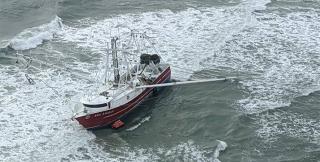 Coast Guard rescuing four fishermen from an 88-foot fishing vessel