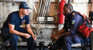 A U.S. Coast Guard officer and a Constable from the Vanuatu Marine Police Wing discuss an upcoming fishery boarding while in Vanuatu’s exclusive economic zone. With coast guard–to–coast guard agreements in place, the U.S. Coast Guard could patrol exclusionary and sovereign waters in concert with host nations.