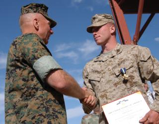 Commandant of the Marine Corps General Michael W. Hagee (left) presents Chontosh, now a captain, with the Navy Cross