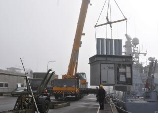 Workers replace a Standard Flex (StanFlex) mission module