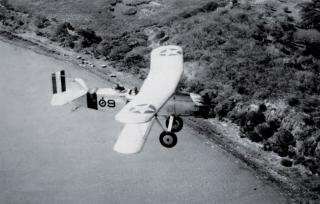 Flying over the shore of Lake Managua is a Curtiss Falcon OC-1, one of the early types of airplanes in which Marines first used dive-bombing as a tactical maneuver in Nicaragua.