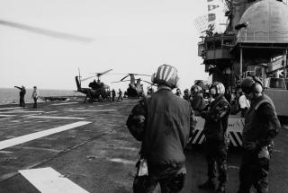 Helicopters are lined up on the deck of the USS Guam (LPH-9) for servicing between missions off the coast of Grenada, 25 October 1983.