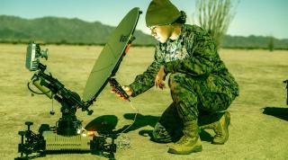 A satellite communications operator with 3d Littoral Anti-Air Battalion, 3d Marine Littoral Regiment,  sets up a multimission terminal. Decoy emitters and electromagnetic signals are essential to deception.