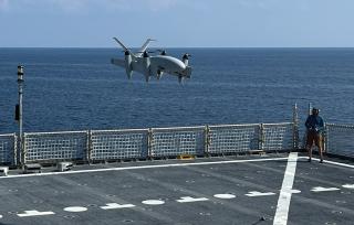 A Transwing unmanned aircraft system is seen here using intelligent autonomous navigation to recover itself without human assistance on the flight deck of the USNS Burlington (T-EPF-10). A future large ULS-A could use a similar design that can fold its wings along the long axis of the fuselage and fly like a traditional fixed-wing aircraft.