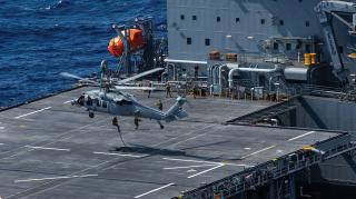 SEALs fast rope onto the deck of the expeditionary sea base USS Miguel Keith