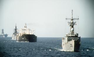 12 October 1987: A starboard bow view of the ships of tanker convoy No. 12 underway in the Persian Gulf.  Included in the convoy are the guided missile frigate USS Hawes (FFG-53), the reflagged tanker Gas King, the guided missile cruiser USS William H. Standley (CG-32), and the amphibious assault ship USS Guadalcanal.