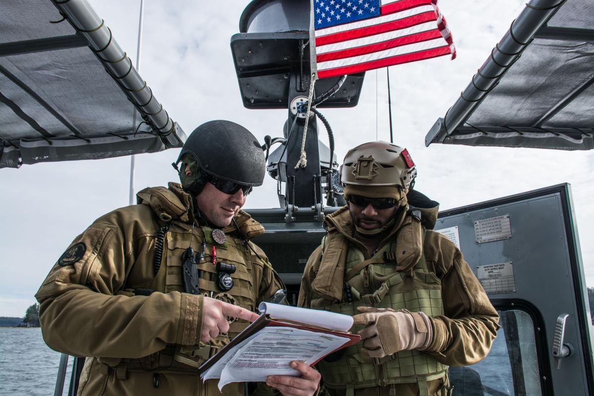 Chief Boatswain's mates review a drill guide during a Coastal Riverine navigational check ride