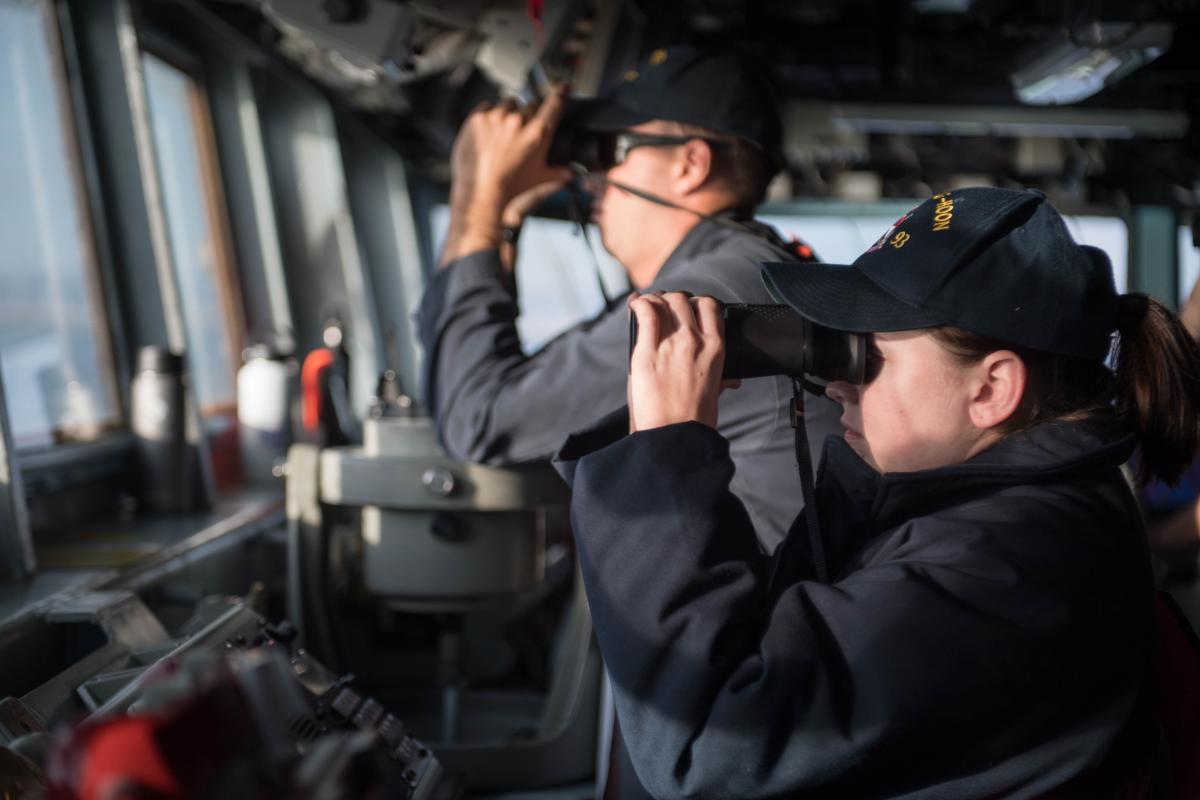 LTJG Lindsey Westfall looks through binoculars on the bridge aboard the guided-missile destroyer USS Chung-Hoon (DDG-93) as the ship pulls into Salalah, Oman.