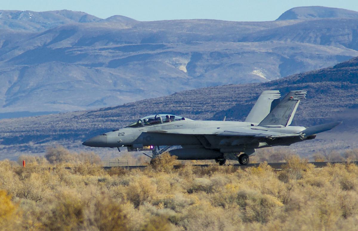 An F/A-18F assigned to Fighter Attack Squadron (VFA) 213 lands at Van Voorhis Airfield at Naval Air Station Fallon, Nevada, during the final phase of carrier air wing training before deploying. Aviation squadron intelligence officers and enlisted intelligence specialists often arrive at the month-long Fallon training phase with little in-depth knowledge of the adversary, the platform they support, or the mission-planning process.