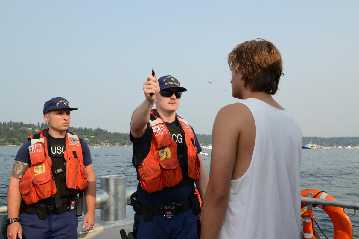 Petty Officer 2nd Drew Allen and Petty Officer 2nd Class Jordan Kuehl perform field sobriety tests on a boater during Seattle’s Seafair, 5 August 2017. 
