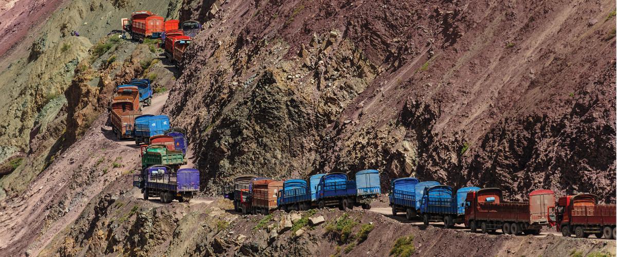A line of Chinese trucks stuck in a traffic jam on a narrow mountain road in the Himalayas.