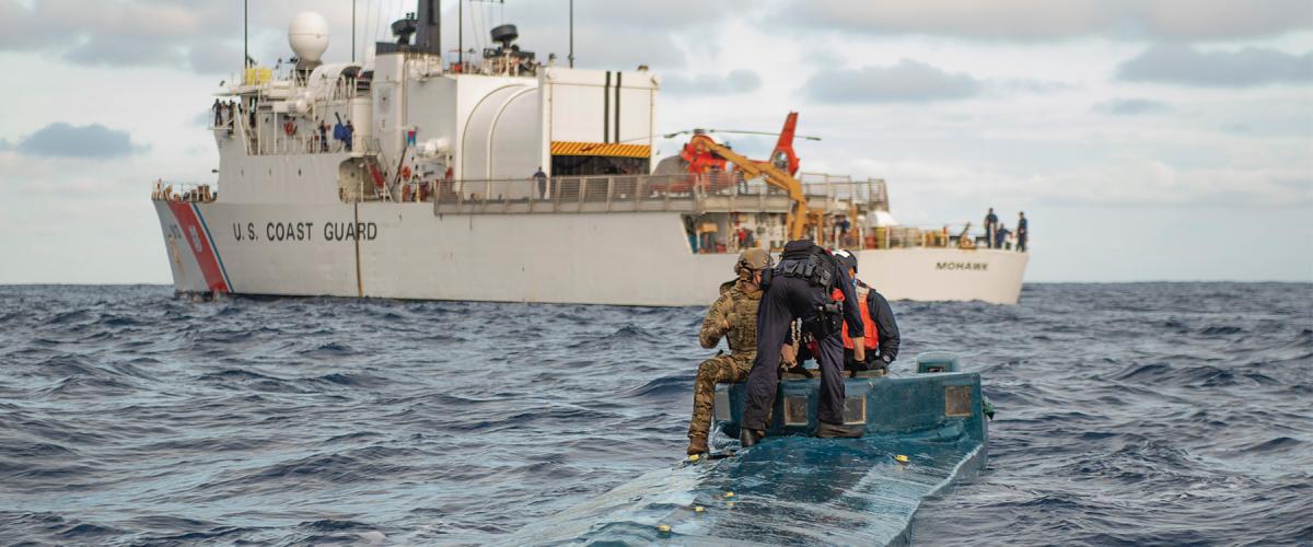 U.S. Coast Guard members offload contraband from a low-profile go-fast vessel to the U.S. Coast Guard Cutter Mohawk (WMEC-913) in the eastern Pacific.