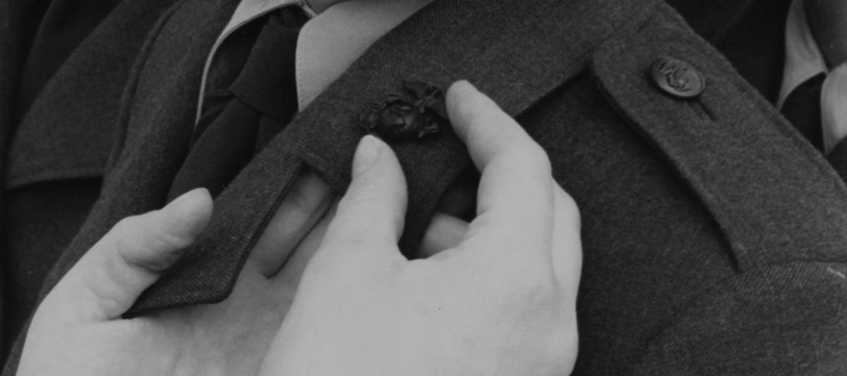 Private Diane Curtis smiles as she receives her Marine Corps emblems during March 1967 graduation exercises at Marine Corps Recruit Depot, Parris Island, South Carolina. The emblem-pinning ceremony signifies the recruit has successfully completed recruit training.