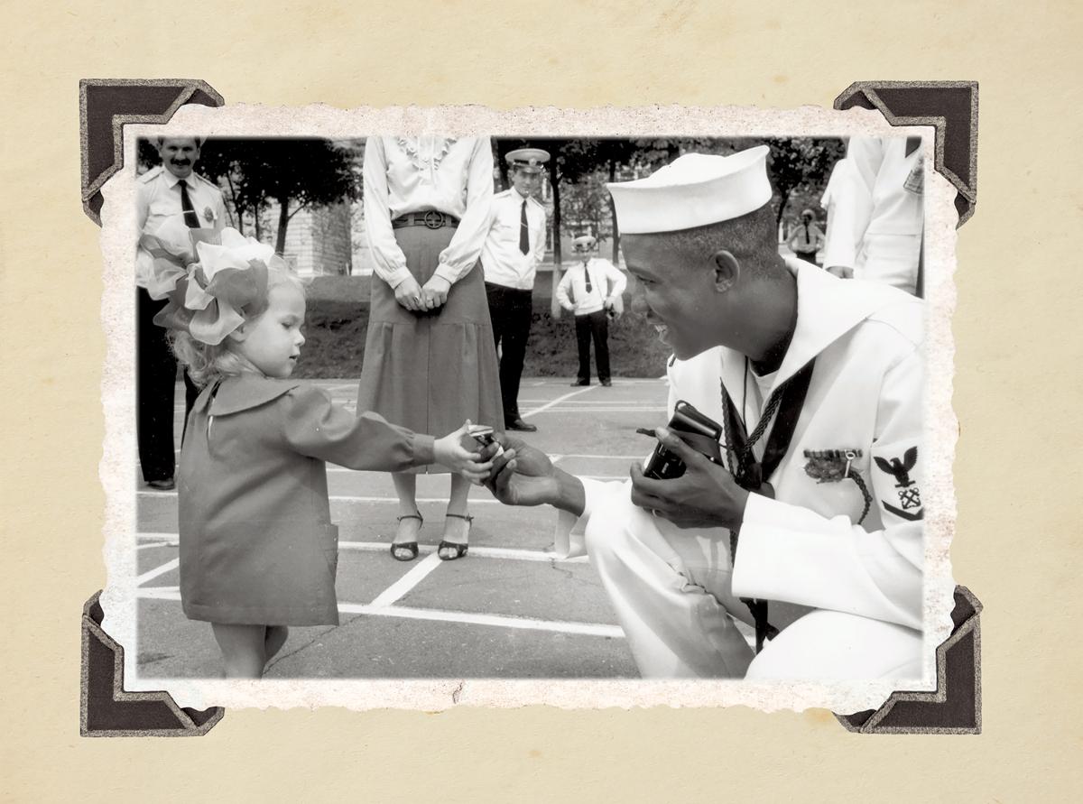 BM3 Demetrius A. Haughbrook offers a piece of candy to  a young resident of Vladivostok, Russia. Sailors and citizens of the area frequently exchanged small gifts during the four-day port visit in 1990. (Jim McGee)