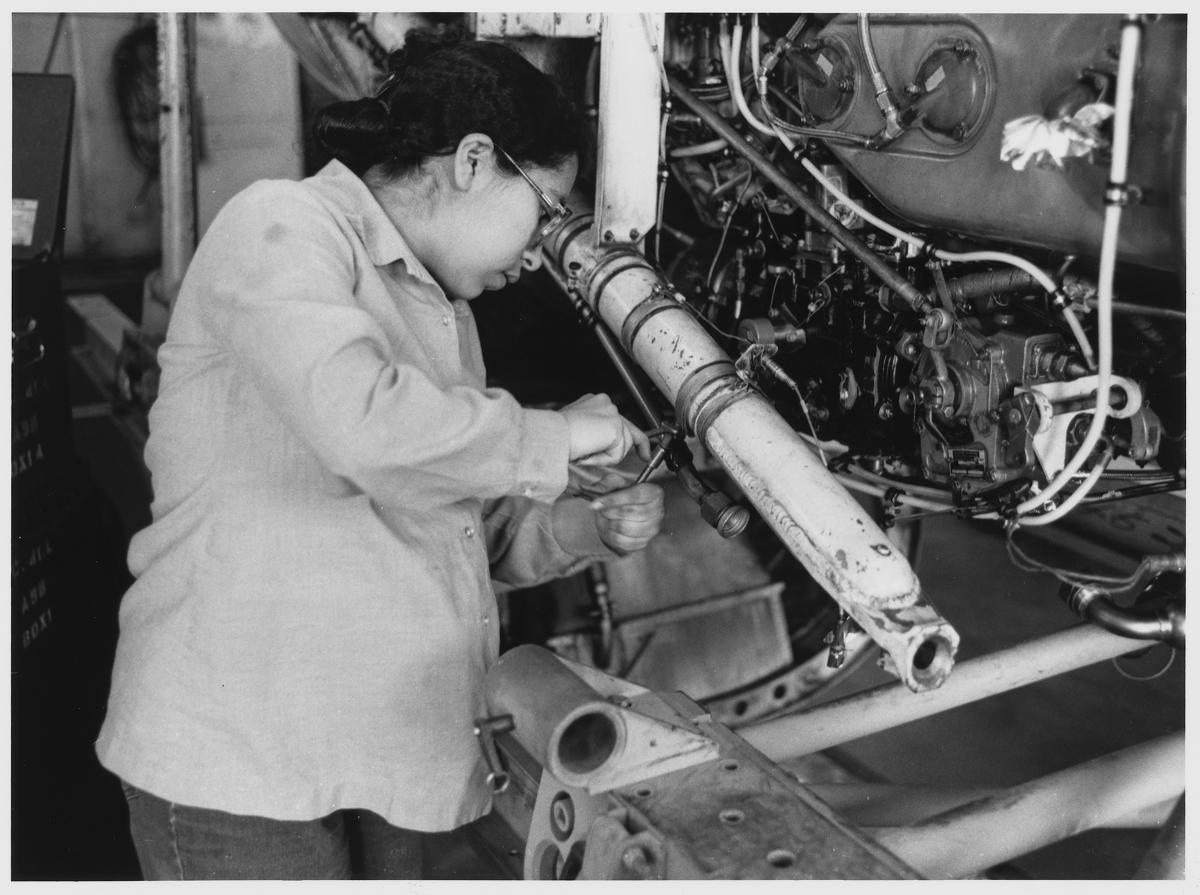 A technician works on an engine. 1980s photographer PH3 Charles Ervin.
