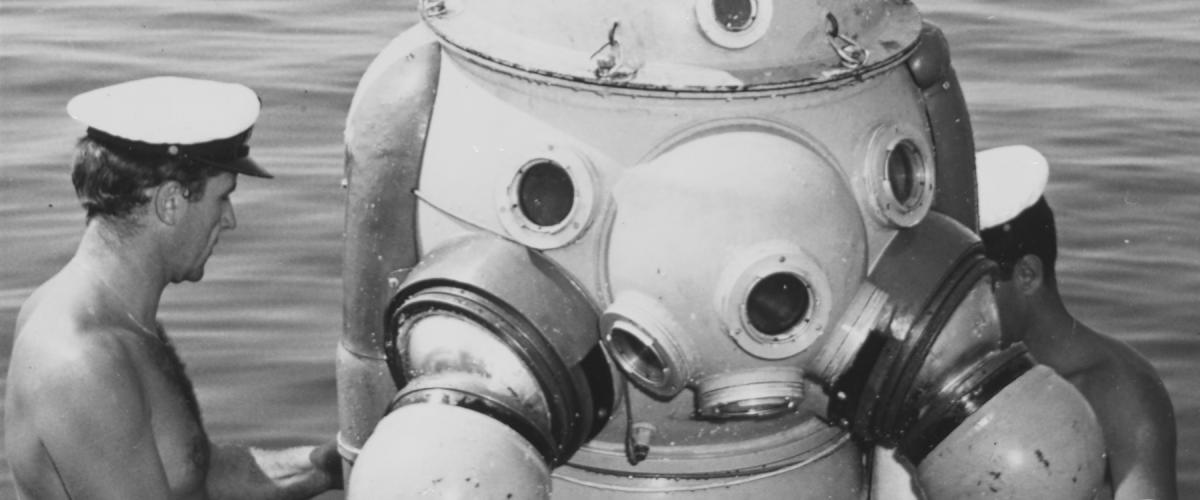 Take her down! Divers on board the Proteo prepare to lower away a fellow deep-sea diver in the ship’s 800-pound armored diving suit.