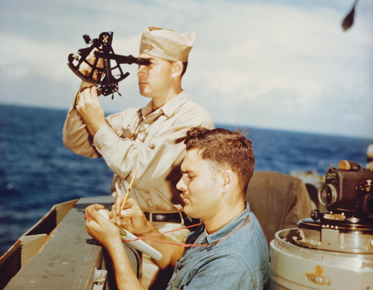 A quartermaster takes a sun sighting from the navigation bridge of the USS Alaska (CB-1) in 1945.