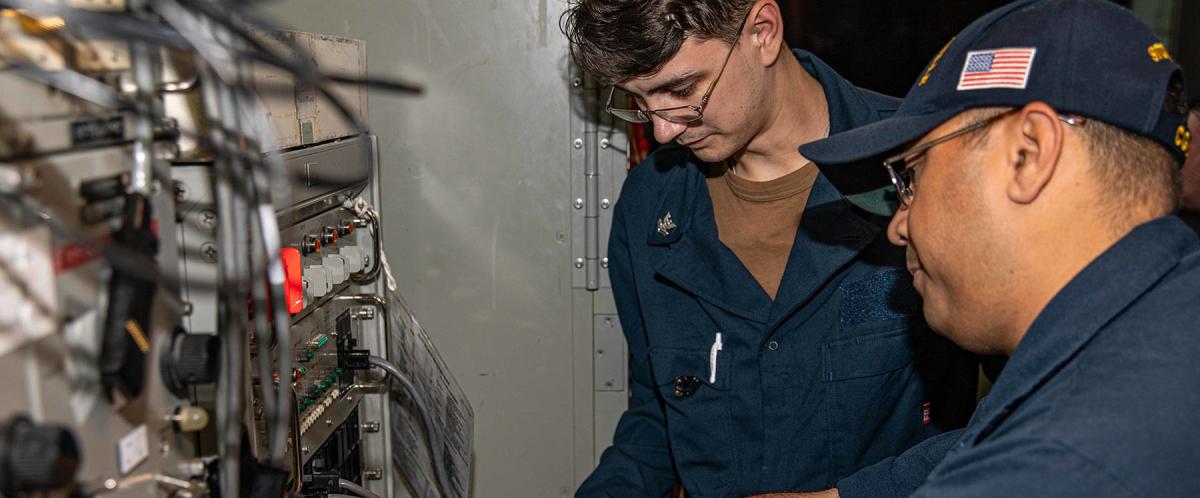 Technicians conduct SATCOM maintenance on board the USS Chancellorsville