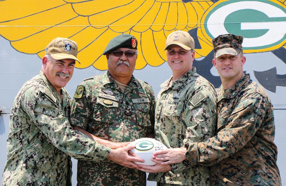 The opening of Tiger Strike 2019, USS Green Bay (LPD-20) commanding officer Captain Michael Harris, Rear Admiral Kacher, and Marine Lieutenant Colonel William Jacobs presented a Malaysian general a Green Bay Packers football as a memento.