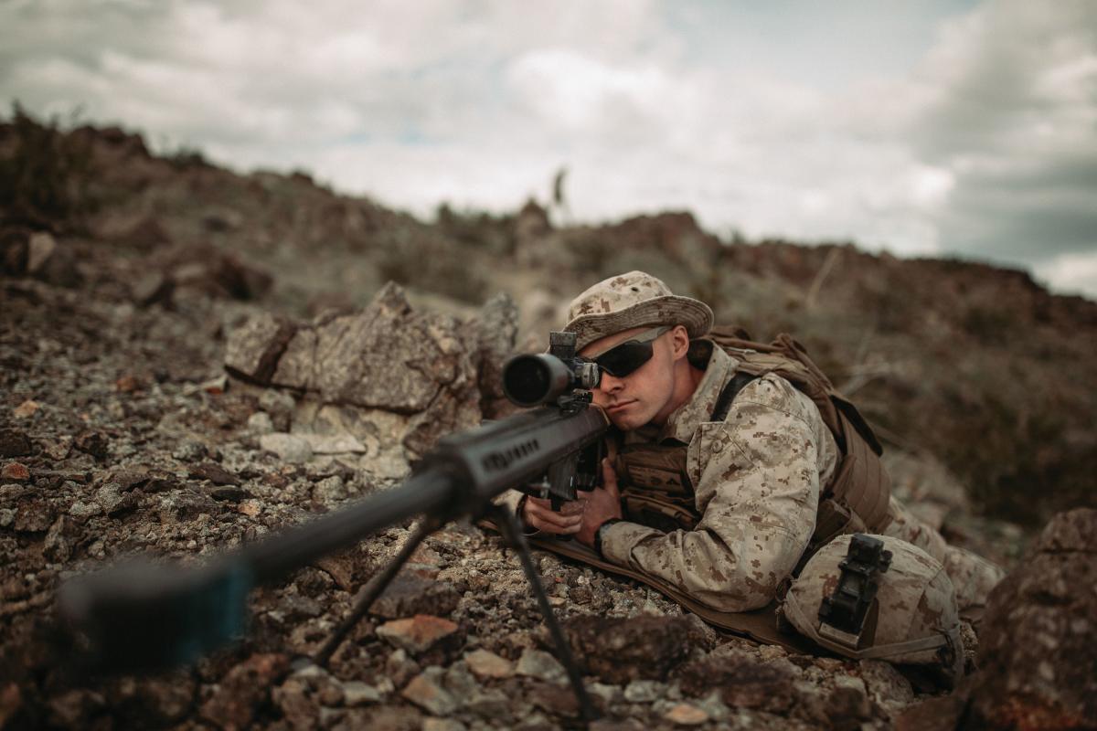 U.S. Marine Corps scout sniper looks down the scope of an M82 Special Applications Scoped Rifle