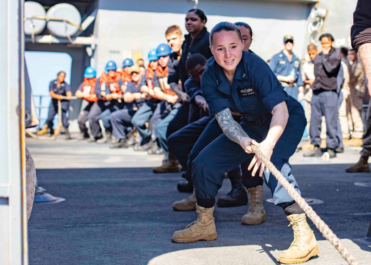 Information Systems Technician 3rd Class Jordan Greenberg heaves a line aboard the San Antonio-class amphibious transport dock ship USS Arlington (LPD-24) during a replenishment-at-sea
