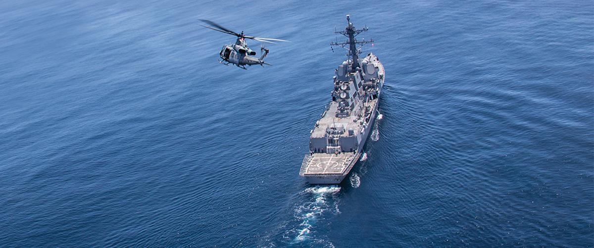 A Marine Corps UH-1Y Venom helicopter with Marine Light Attack Helicopter Squadron 469 flies over the USS John Finn (DDG-113). The teamwork of land, sea, and air forces and the central role of scouting—“information acquisition”—will be essential to littoral combat in the western Pacific and anywhere else the Navy and Marine Corps must team up to fight.