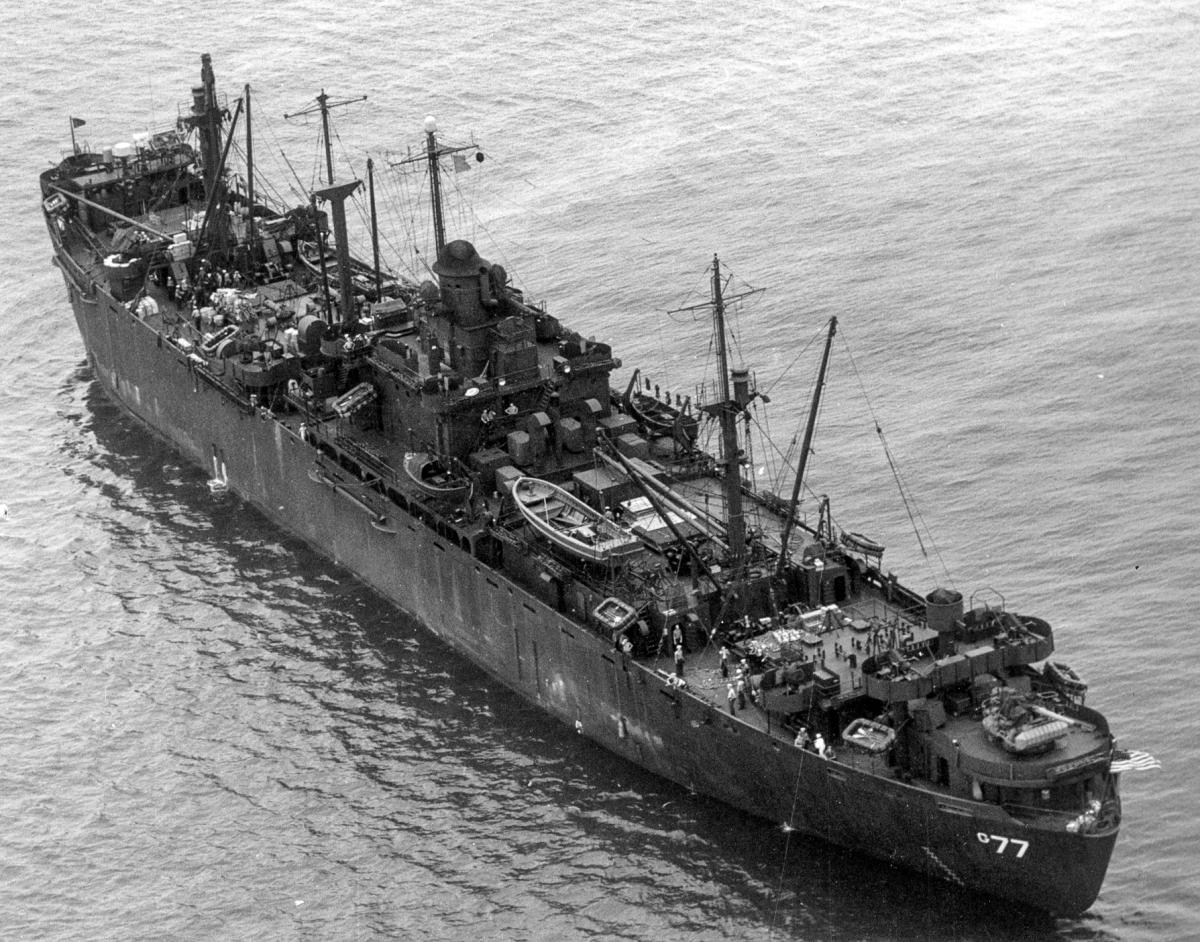 Aerial oblique stern quarter view of the USS Indian Island (AG-77) at anchor
