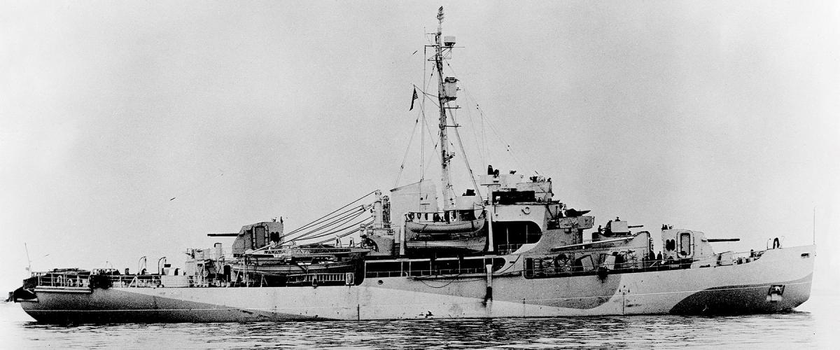 The Eastwind is shown off the coast of Greenland in her World War II state, including her Arctic camouflage. Note the twin dual 5-inch/38-caliber gun houses fore and aft.