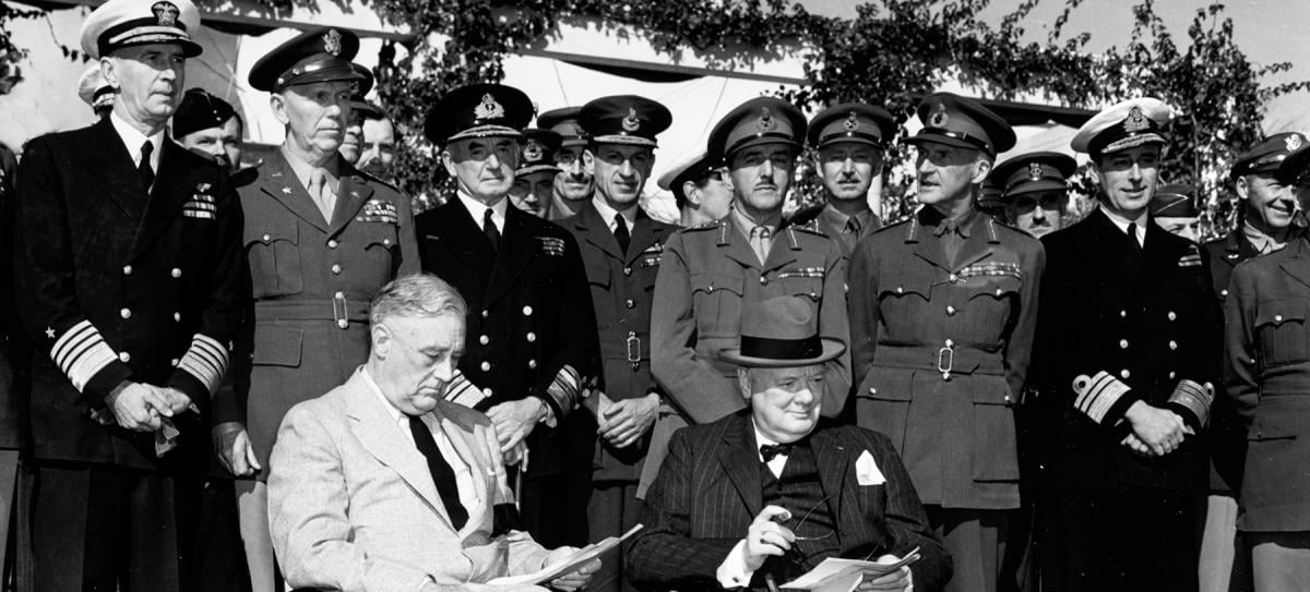 January 1943: U.S. President Franklin Roosevelt (seated left) and British Prime Minister Winston Churchill (seated right) gather with their Combined Chiefs of Staff in Morocco for the Casablanca Conference. (Standing, left to right: Admiral Ernest J. King, USN; General George C. Marshall USA; Admiral Sir Dudley Pound, Air Chief Marshal Sir Charles Portal, General Sir Alan Brooke, Field Marshal Sir John Dill, Admiral Lord Louis Mountbatten.)