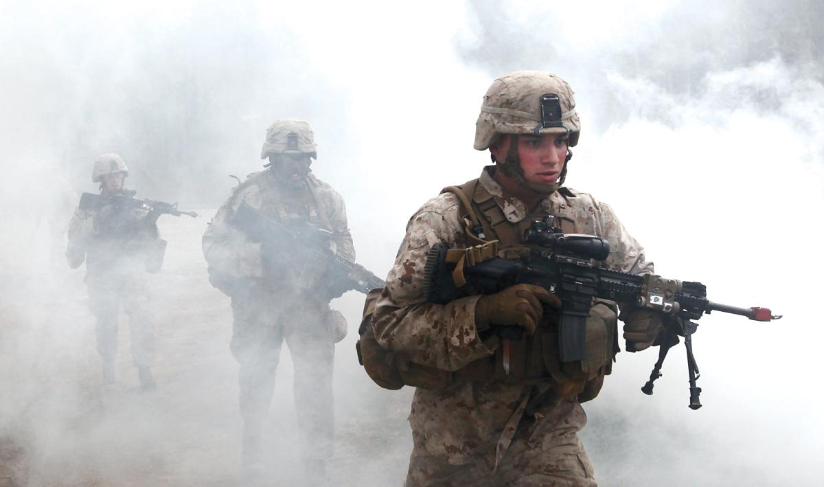 U.S. Marines with Fox Company, Battalion Landing Team 2/6, 26th Marine Expeditionary Force, use a smoke grenade to screen their movement as they prepare to enter a building during military operations in urban terrain (MOUT) training at Fort Pickett, Va., April 11, 2015