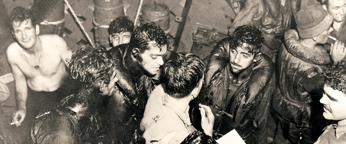 Oily survivors from the torpedoed USS Helena are taken aboard the USS Nicholas (DD-449) after the July 1943 Battle of Kula Gulf. 