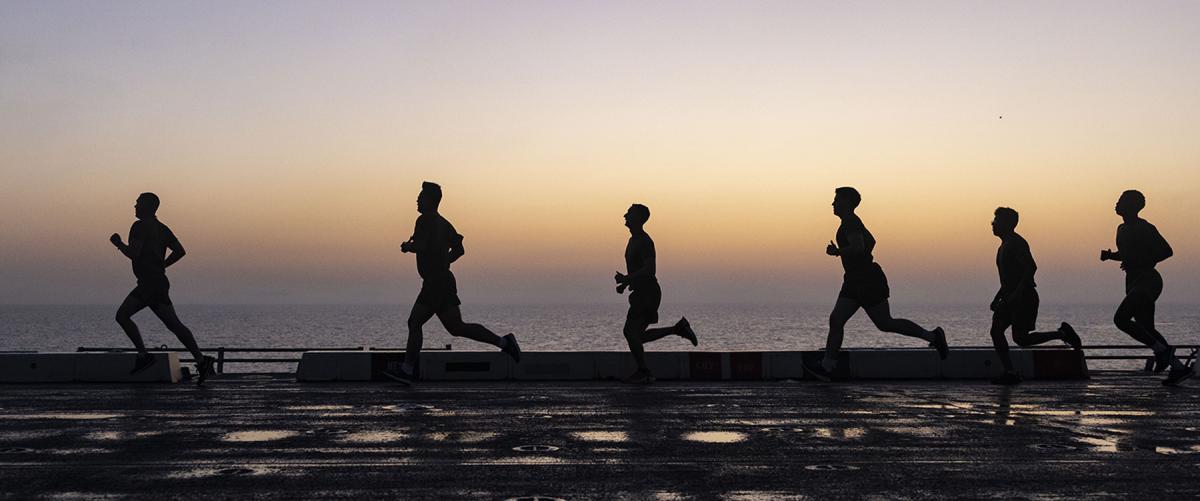 U.S. Marines and sailors run on the flight deck of the USS Mesa Verde (LPD-19). Information warriors operating in the cyber domain are a distinct class of warfighter. Recruiting requirements should reflect this reality. 