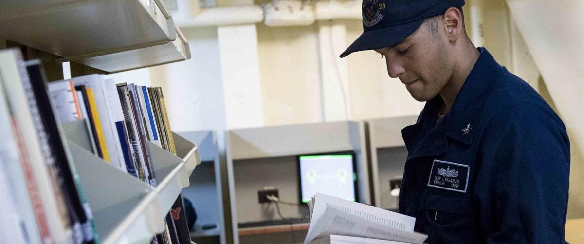 A sailors examines the library on the USS Anchorage (LPD-23)