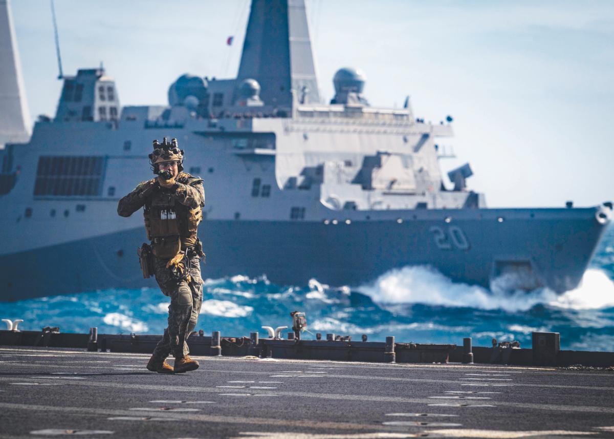 A Force Reconnaissance Marine with the 31st Marine Expeditionary Unit (MEU) clears the flight deck of the amphibious dock landing ship USS Ashland (LSD-48) 