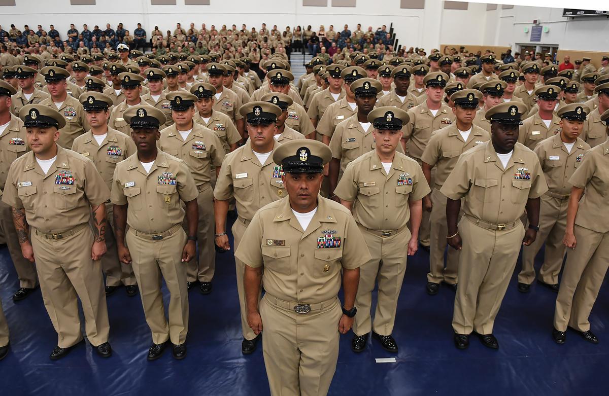 Members of Naval Station Mayport's Chief's Mess stand at attention during a Chief Petty Officer pinning ceremony at the base gy
