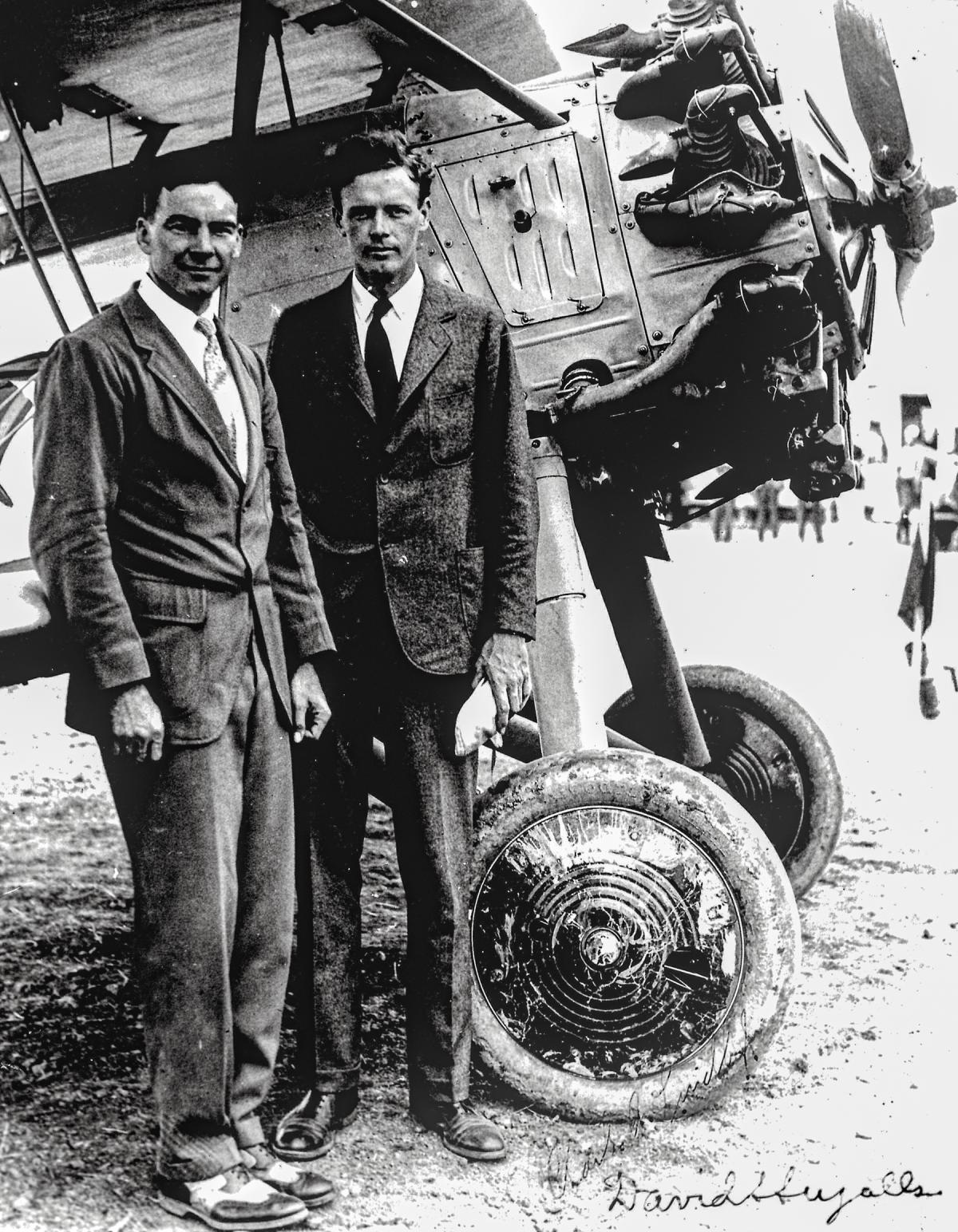 Assistant Secretary David Ingalls, left, and aviation pioneer Charles Lindbergh stand in front of a U.S. Navy “High Hat” aircraft