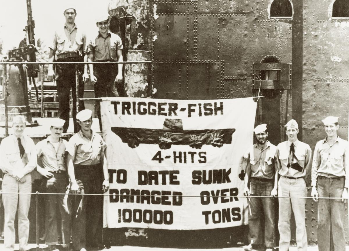 Trigger (SS-237) crew pose with a sign showing the submarine’s reported toll on Japanese shipping. The carrier depicted is the Hiyō, on which four hits were claimed.