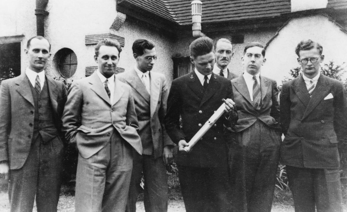 Midshipman Truax, holding an experimental liquid-fuel rocket motor, poses with members of the British Interplanetary Society in July 1938.