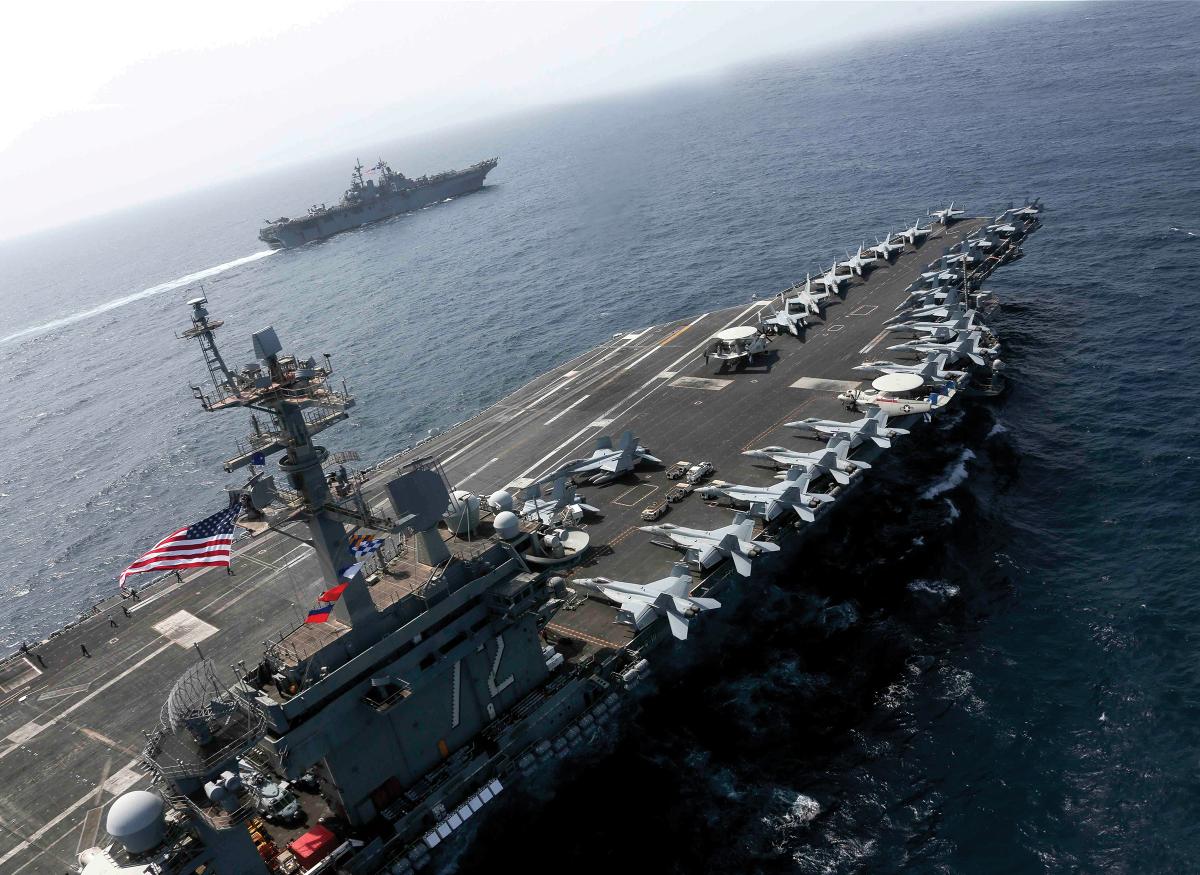 Large nuclear-powered aircraft carriers, such as the USS Abraham Lincoln (CVN-72), shown here, deliver much more combat power than smaller “Lightning” carriers, such as the USS Kearsarge (LHD-3), shown in the distance.