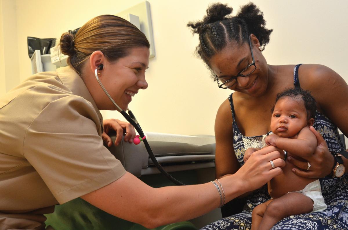 Lt. Allison Wessner, a pediatrician at Naval Hospital Jacksonville, conducts a check-up with a two-month-old and her mother.
