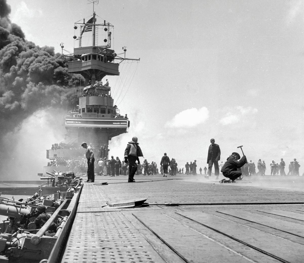  Crewmen repair bomb damage to the flight deck of the USS Yorktown (CV-5) on 4 June 1942 during the Battle of Midway
