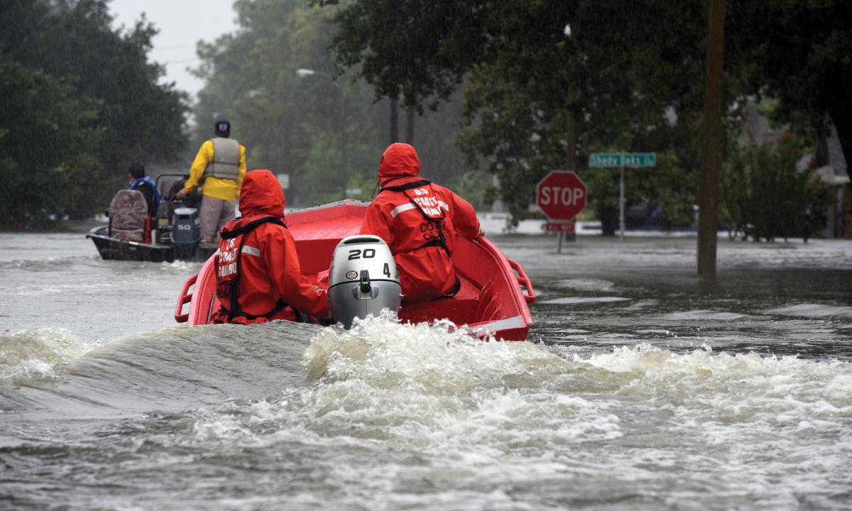 Coast Guardsmen pilot a 16-foot flood punt boat and join good Samaritans in patrolling a flooded neighborhood in Friendswood, Texas